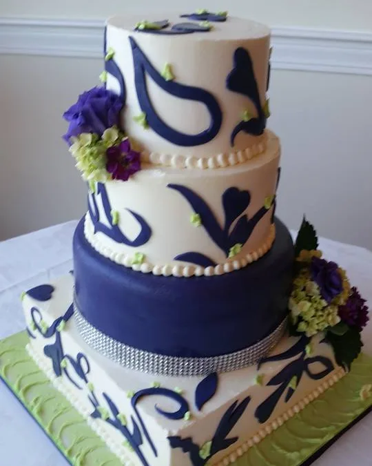 Cake with navy paisley design, lime green base and fresh flowers