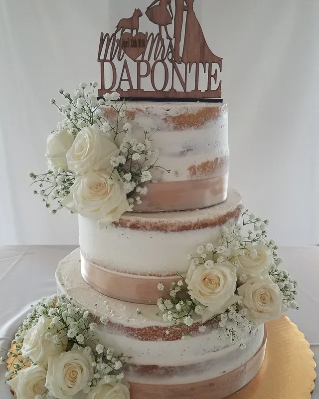 Semi-naked wedding cake with ivory roses and baby's breath