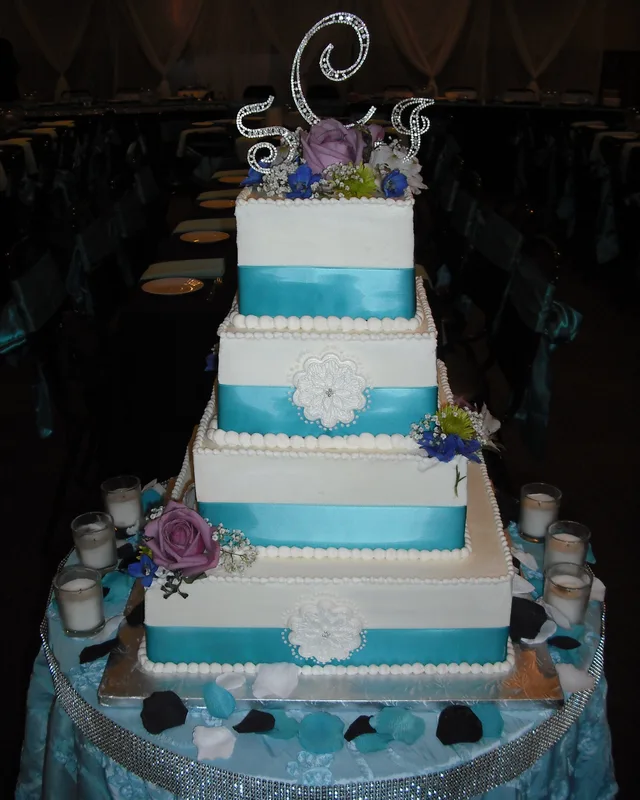 Square cake with turquoise ribbon and a crystal monogram topper