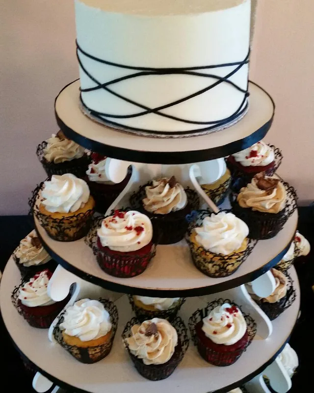 Cupcake tower topped with a small ribbon-laced cake