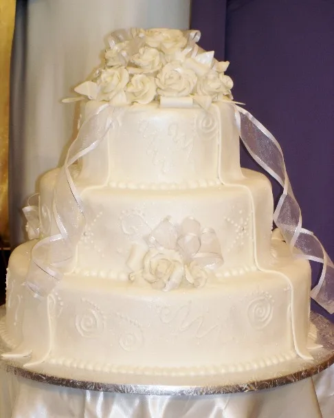 Ivory cake with sugar roses and sheer ribbon